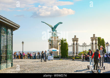 Touristen, wandern und auf Segways, Sammeln von der Turul bird Statue mit Blick auf Budapest, Ungarn auf der Terrasse der Burg von Buda. Stockfoto