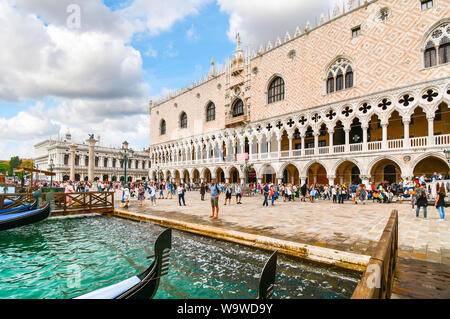 Touristen zu Fuß der Riva degli Schiavoni vor der Doge Palast, Palazzo Ducale und dem Markusplatz entlang des Canal Grande in Venedig, Italien Stockfoto