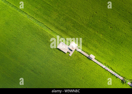 Bild des Schönen terrassierten Reisfeldern in Wasser und Bewässerung von Drone, Ansicht von oben von rices Reisfeld mit Holzbrücke. Stockfoto