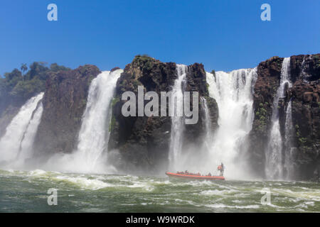 Motorboote venture mit Touristen in der Nähe der Wasserfälle von Iguazu Fluß in sonnigen Sommertag. Foz de Iguaçu teilt die Grenze zwischen Brasilien und Argenti Stockfoto