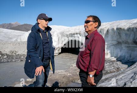 Pond Inlet, Kanada. 15 Aug, 2019. Bundesaußenminister Heiko Maas (l, SPD) spricht zu einem Park Ranger über einen Gletscher Wanderung in der Nähe von Teich Einlass, in der kanadischen Arktis. Der kleine Inuit Siedlung mit nur 1.300 Einwohnern wird sich mit den Folgen des Klimawandels, die nirgendwo deutlicher als in der Arktis. Credit: Kay Nietfeld/dpa/Alamy leben Nachrichten Stockfoto