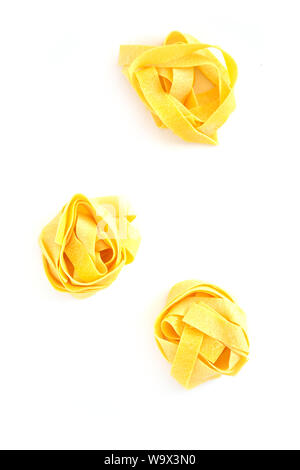 Raw pappardelle Italienische Eiernudeln Nester auf weißem Hintergrund in Flach Zusammensetzung Stockfoto