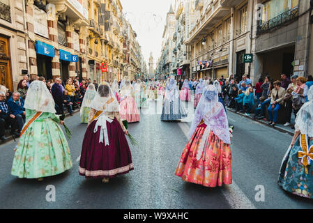 Valencia, Spanien - 17. März 2019: Fallera Kommission paradieren Calle de la Paz, von hinten gesehen, während der Fallas bietet. Stockfoto