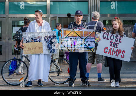 New York, USA. 15 Aug, 2019. Mitglieder der Aktivist Gruppe Aufstieg und widerstehen und betroffenen New Yorker ein stiller Protest am 15. August 2019 Im Plaza außerhalb der Staten Island Ferry Terminal gehalten, keine Überfälle/SCHLIESSEN DIE CAMPS/ICE Banner abzuschaffen, Fotos von den Kindern, die in der Haft gestorben, und Fotos von den Internierungslagern der Grenzschutz und Eis, grausame und unmenschliche Behandlung von Einwanderern, Flüchtlingen und Asylbewerbern. Credit: Erik McGregor/ZUMA Draht/Alamy leben Nachrichten Stockfoto