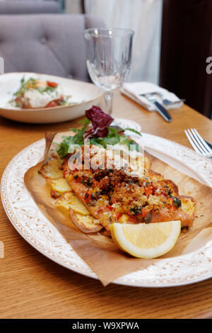 Gebratenes Forellenfilet mit Gemüse und Kartoffeln, italienische Gericht Stockfoto