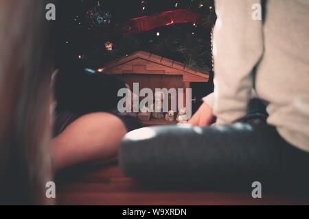 Nahaufnahme von Personen, die in der Nähe von kleinen Figuren sitzen Stockfoto