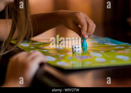 Mehrfarbige spiel Chips mit Würfeln auf dem Spielfeld. Brettspiel. Kinder im Kindergarten am Tisch sitzen, erfahren Sie in den Kindergarten, Spielen Stockfoto