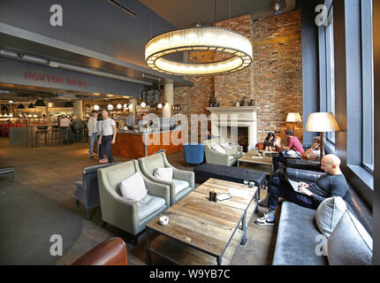 Kunden in die Eingangshalle, die Bar und das Restaurant im Londoner angesagten Hoxton Hotel in Shoreditch, UK entspannen Stockfoto