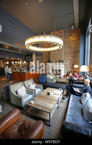 Kunden in die Eingangshalle, die Bar und das Restaurant im Londoner angesagten Hoxton Hotel in Shoreditch, UK entspannen Stockfoto