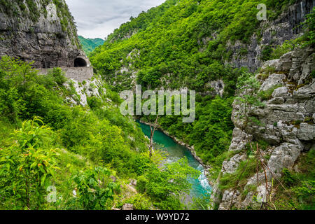 Montenegro, Straße Verkehr durch Tunnel in moraca Canyon neben wunderschönen türkisen Gewässern der Moraca-fluss Stockfoto