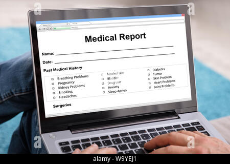 Mann Füllung Patientendaten Form auf digitalen Laptop Stockfoto