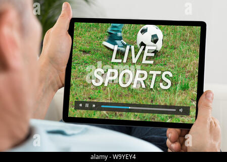 Mann Live Fußballspiel auf digitalen Tablet Stockfoto