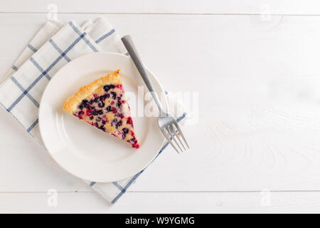 Torte mit roten Johannisbeeren und Heidelbeeren auf weißem Holz- Hintergrund. Kopieren Sie Platz. Ansicht von oben. Stockfoto