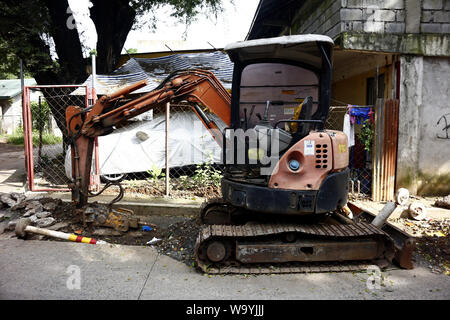 ANTIPOLO CITY, Philippinen - August 12, 2019: Ein kleiner Bagger auf einer Straße Baustelle geparkt. Stockfoto