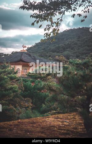 Vertikale Aufnahme eines japanischen Tempels umgeben von Bäumen und Berge Stockfoto