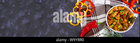 Rühren braten Huhn mit Paprika und Champignons auf dunklem Hintergrund. Ansicht von oben. Banner. Stockfoto
