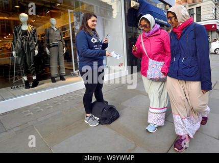 London, England, UK. Frau verteilen Flugblätter in der Oxford Street Stockfoto