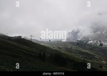 Entfernte Aufnahme einer Seilbahn in der Nähe von Bergen, umgeben von Bäumen Stockfoto