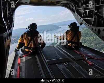 Rescue Techniker mit dem Pennsylvania Hubschrauber Aquatic Rescue Team Blick aus dem Rücken eines CH-47 Chinook Hubschrauber nach einem Notfallplan Übung in Harrisburg, Pennsylvania, 15 August, 2019. 28 ECAB Soldaten mit ihren Partnern in PA-HART und andere Zivile Einsatzkräfte während der Übung gearbeitet, genannt "Operation Hurricane." PA-HART ist eine gemeinsame Partnerschaft zwischen der Pennsylvania National Guard, Pennsylvania Fisch und Boot Kommission, Pennsylvania Emergency Management Agency und zertifizierte zivile Rettung Techniker. Es ist eine Antenne Such- und Rettungsteam, in der Lage zu helfen citize Stockfoto