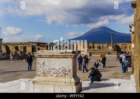 Pompeji, Italien Foro di Pompeji, mit dem Vesuv im Hintergrund. Forum von Pompeji mit dem Besucher vor der archäologischen Überreste der Tempel des Jupiter. Stockfoto