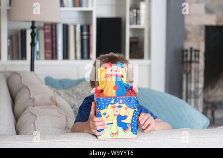 Aufnahme eines kleinen Jungen, der mit einem Clown spielt Eine Kiste Stockfoto