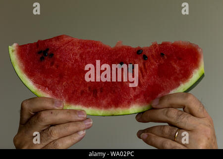 Sommer Obst Wassermelone, männliche Hände halten ein Stück Wassermelone Stockfoto