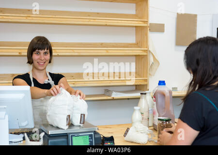 Female Shop Assistant ein Kunde an einem Schreibtisch. Stockfoto