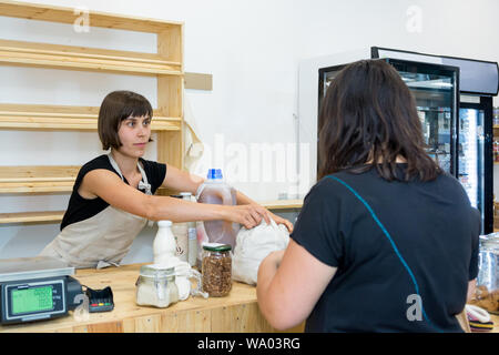 Female Shop Assistant ein Kunde an einem Schreibtisch. Stockfoto