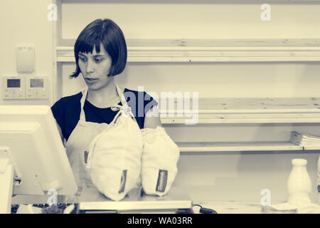 Female Shop Assistant ein Kunde an einem Schreibtisch. Stockfoto