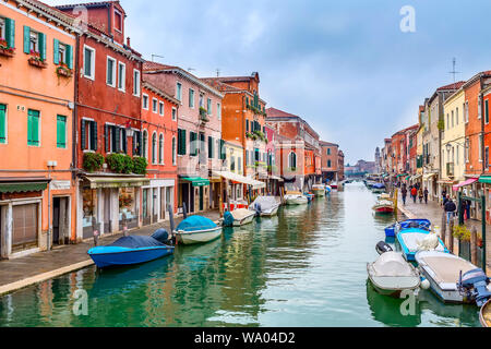 Die Insel Murano, Venedig, Italien - 11. November 2014: Kanal mit Booten, bunte Häuser und Menschen auf der Straße Stockfoto