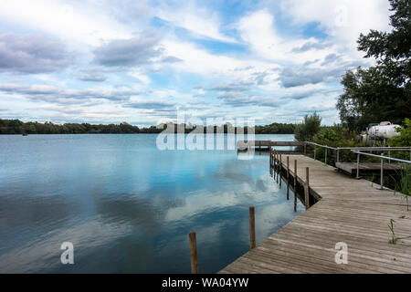 Blick auf einen See in Reading, Großbritannien. Eine ruhige Szene mit Wolken im Wasser spiegelt. Stockfoto