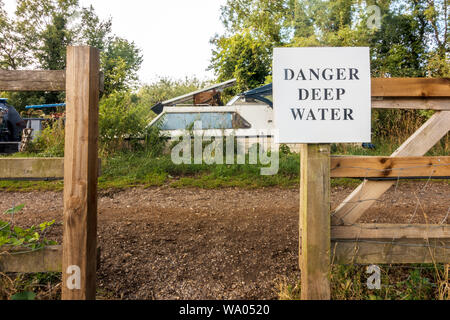 Ein Zeichen, wie sie durch einen Zaun auf den Weg entlang des Flusses Kennet bei Lesung in der Berkshire, Großbritannien warnt vor der Gefahr der tiefen Wasser, Stockfoto