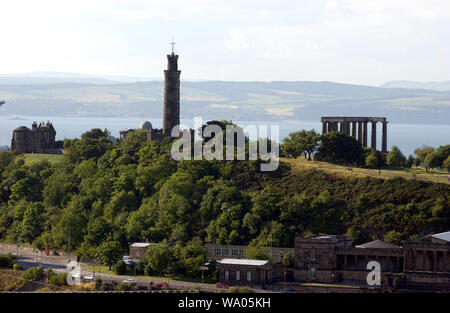 Calton Hill, Edinburgh, Schottland, Großbritannien mit dem Firth der Vierten und den Hügeln von Fife darüber hinaus. Im Bild oben auf dem Hügel sind die Sternwarte, Links, Nelsons Monument, das Zentrum und der Athener Akropolis oder National Monument, rechts. Im Vordergrund an der Unterseite des Hügels ist der alte Royal High School. 1/8/01. Stockfoto