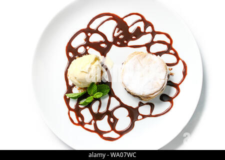 Französische Dessert millefeuille, mit Schokolade Sirup und Vanilleeis auf weißem Hintergrund. Mit Minze auf einem weißen Teller serviert. Stockfoto