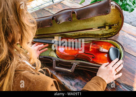 Frauenhand mit Violine und Koffer für Violine Stockfoto