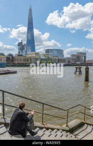 Ein Geschäftsmann auf Schritte, die von der Seite der Themse im Zentrum von London über den Fluss in Richtung der shard Bürogebäude suchen. Stockfoto