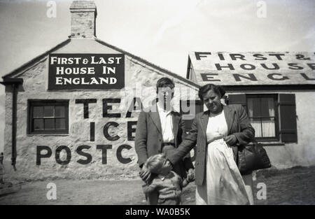 1950, historische, eine Mutter mit ihren beiden Söhnen und außerhalb der 'Erste & letzte Haus in England", ein altes Landhaus, das als Kaffee und einen kleinen Laden, in dem Eis und Souvenirs an der Küste bei Lands End, Cornwall, England, Großbritannien. Stockfoto