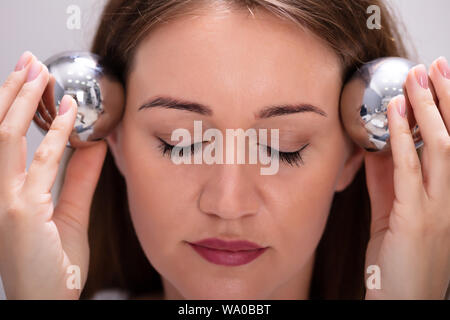Nahaufnahme der jungen Frau die Meditation Mit chinesischen Stress Ball Stockfoto