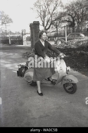 1960, historische, England und eine Dame in einem Rock draußen sitzen auf einer Vespa Motorroller, ein italienischer Motorroller in der Toskana von Piaggio, die 1946 gegründet wurden, hergestellt. Stockfoto