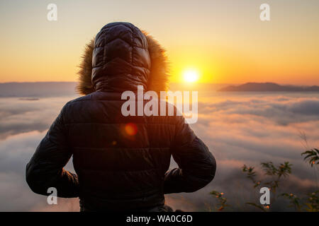 Sunrise Frau Mantel den Sonnenaufgang und neblig. Stockfoto