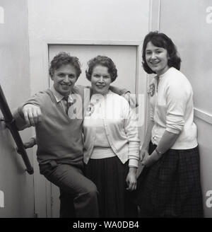 1958, historische, auf einer Treppe, der englische Sänger Tommy Steele mit zwei seiner jungen weiblichen Fans. Geboren Thomas Hicks in Bermondsey, London 1936, Tommy Steele, wie er bekannt wurde, war der erste teen Idol und Rock and Roll Star in Großbritannien. Stockfoto