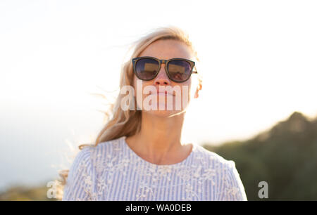 Junge blonde Natürliche kaukasische Frau in Sonnenbrille portrait draußen in der Natur Stockfoto