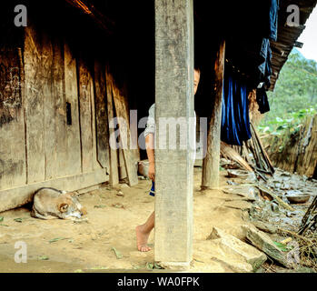 Ein junger Bauer junge versteckt sich hinter einer Säule vor dem Haus in Sapa, Vietnam Stockfoto