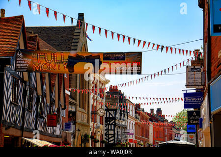 Bunting hing zwischen Geschäften in der Bohrung Straße, Lichfield, England, Großbritannien Stockfoto