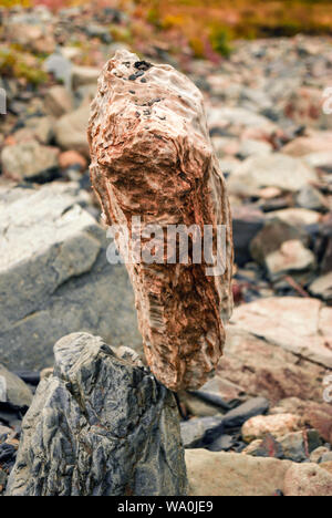 Helle, natürliche Kopfsteinpflaster steht senkrecht in empfindliche Balance auf einem anderen Stein Stockfoto