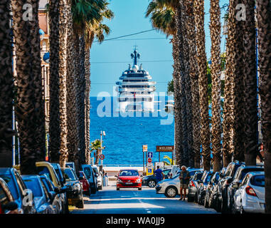 Juan-les-Pins, Frankreich - Juli 6., 2018: Palmen gesäumten Boulevard, die zu Luxusyacht auf Ozean Stockfoto