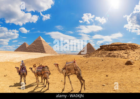 Die Pyramiden und Kamele mit Beduinen in der Wüste von Gizeh, Ägypten Stockfoto