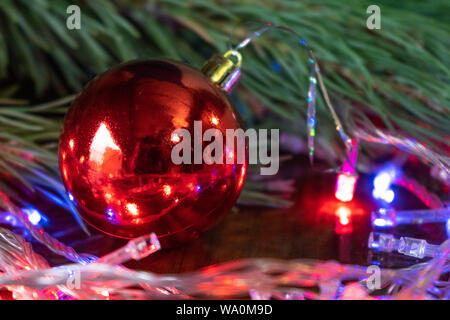 Weihnachtsdekor Bitcoins, Kugel auf einem Holzbrett mit Kiefernzweigen und Urlaub. Münzen bitcoin unter dem Zweig von einem Weihnachtsbaum, auf der Boa Stockfoto