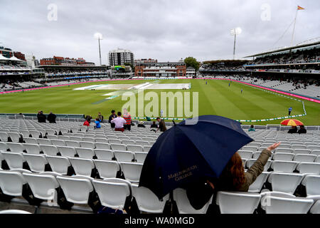 Zuschauer Unterschlupf vor dem Regen als Spiel wird durch schlechtes Wetter in Tag drei der Asche Test Match auf Lord's, London verzögert. Stockfoto