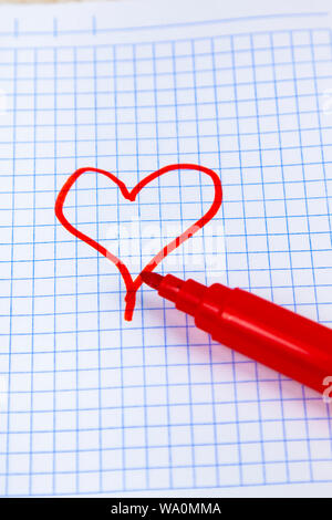 Filzstifte und Notebook. Rotes Herz ist auf einem karierten Blatt gezeichnet. Stockfoto
